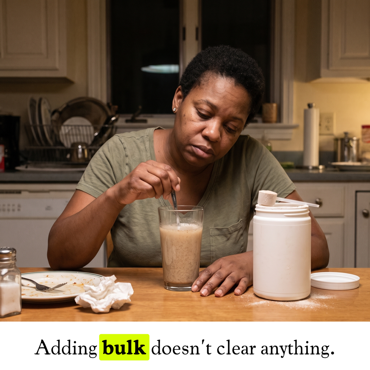 A woman wincing right after taking a tablespoon of Soursop Bitters